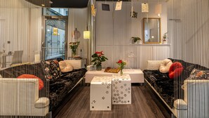 Een moderne woonkamer met een bank, salontafel en decoratieve objecten.