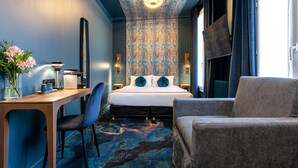 Een moderne hotelkamer met een bed, een bureau, een stoel en een bank.