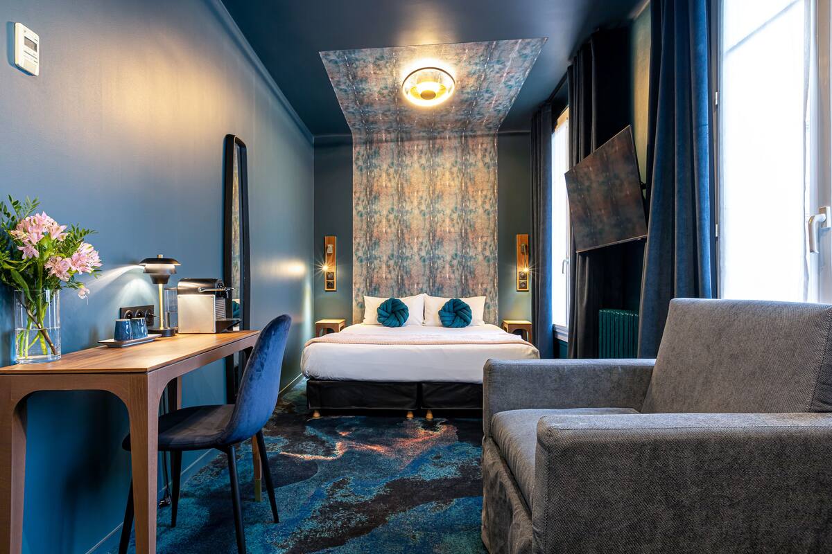 Une chambre d’hôtel moderne équipée d’un lit, d’un bureau, d’une chaise et d’un canapé.