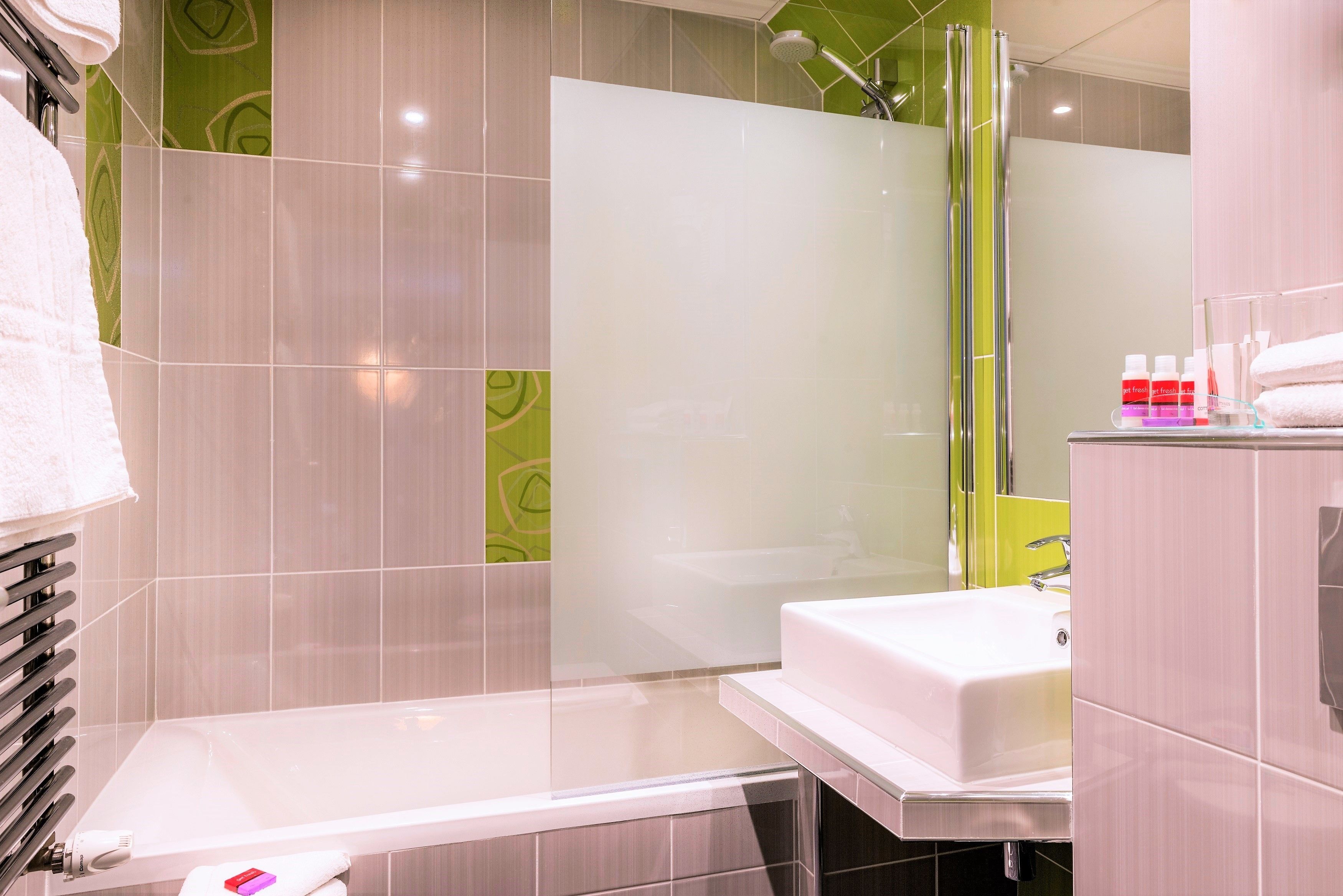 A modern bathroom with a bathtub, a shower, and a sink.