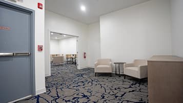 Un vestíbulo de hotel con piso alfombrado, un mostrador de recepción y una zona de estar.