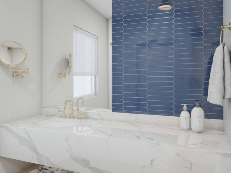 A bathroom with a marble sink, gold fixtures, a blue tiled wall, and two bottles of shampoo.