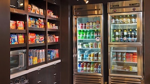 Zona de máquinas expendedoras con microondas y opciones de snacks.