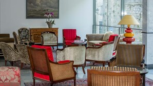 A spacious room with a large window, a painting, and a variety of chairs and tables. - ibis Périgueux Centre (Périgueux)