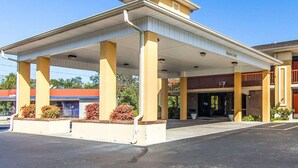 A gas station with a covered canopy, a brick building entrance, and a clear blue sky. - Quality Inn Sweetwater West (Sweetwater)
