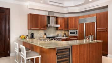 Una cocina moderna con armarios de madera, encimera de granito, electrodomésticos de acero inoxidable y horno empotrado.