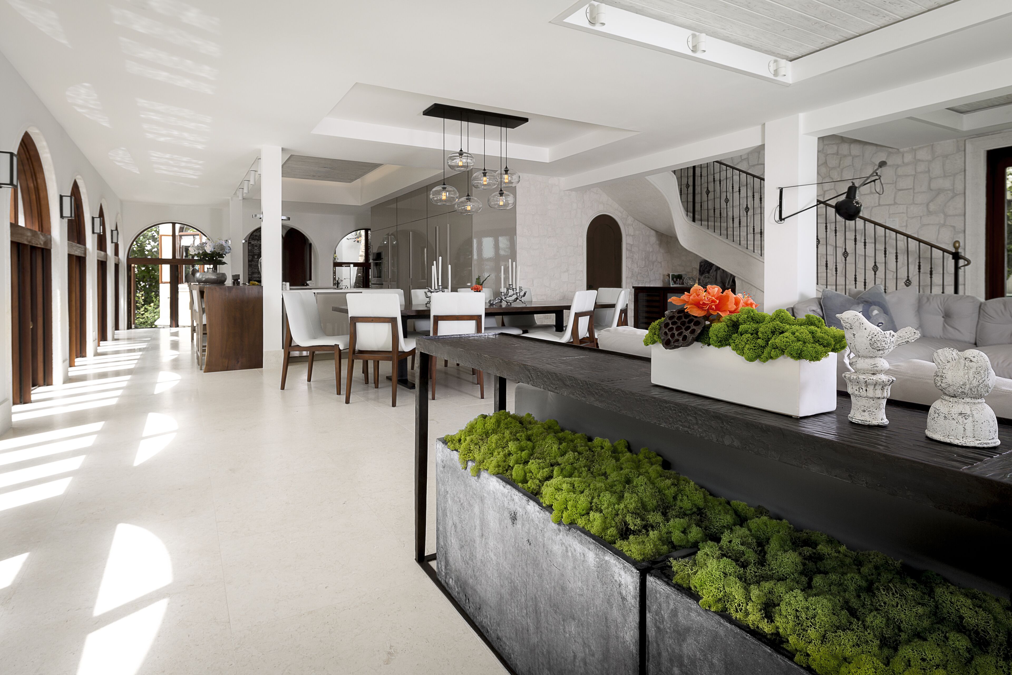 Una cocina espaciosa con una isla grande, iluminación colgante moderna y una pared decorativa de piedra.