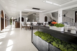 A spacious kitchen with a long island, modern pendant lighting, and a stone accent wall.