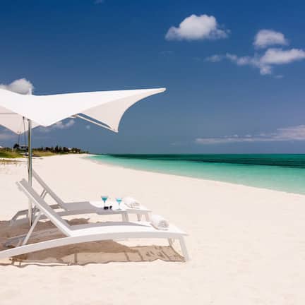 On the beach, white sand, sun loungers, beach umbrellas