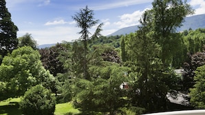 A balcony with a pool, dining table with breakfast items, and a view of a lush garden and mountains. - Hotel Ibis Styles Aix-les-Bains Domaine de Marlioz (Aix-les-Bains)