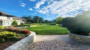 A well-maintained garden with a paved pathway leading to a house with a visible balcony. - Hotel Ibis Styles Aix-les-Bains Domaine de Marlioz (Aix-les-Bains)