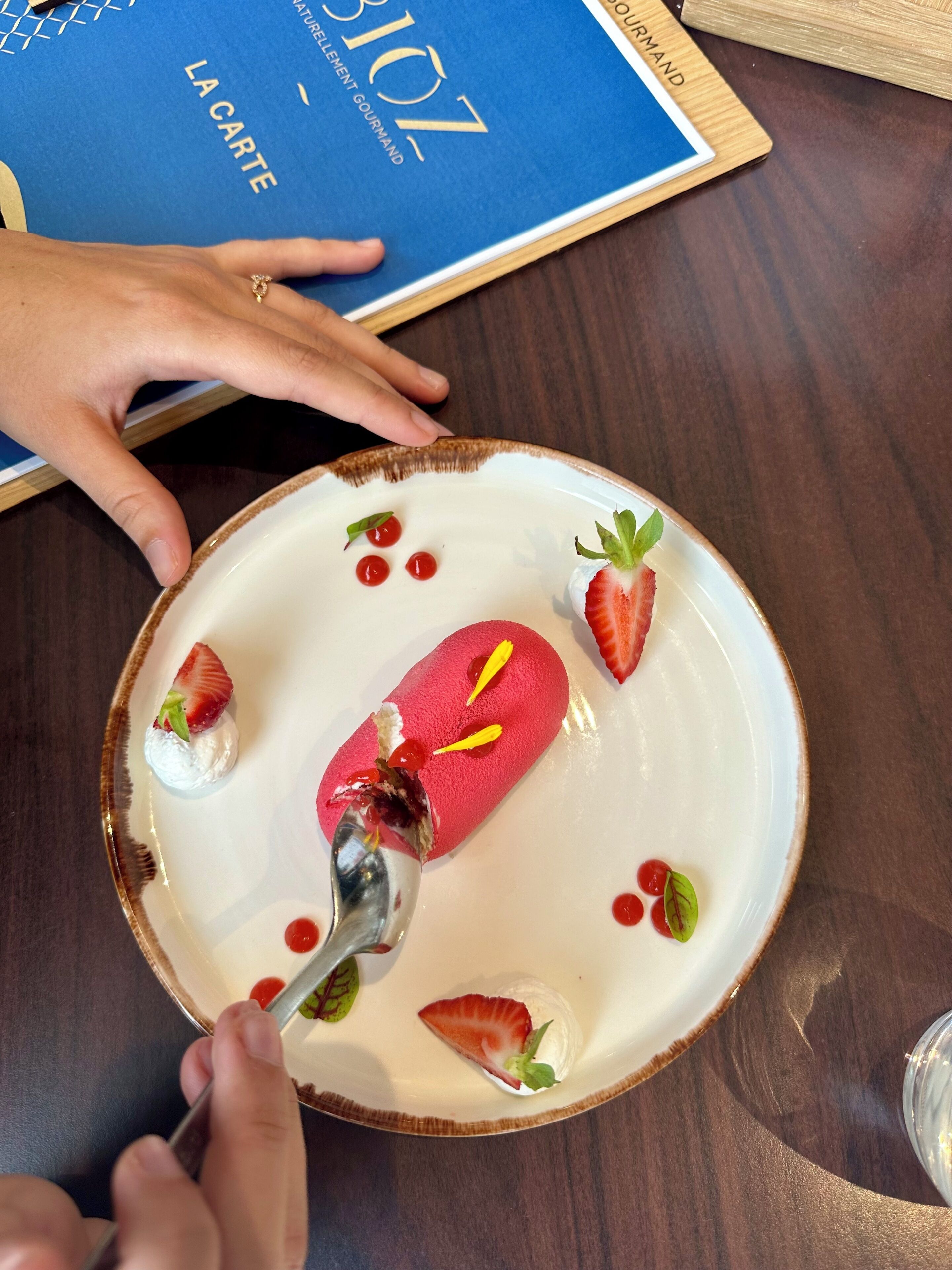 A dessert plate with a scoop of ice cream and strawberries on a white plate.