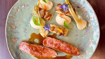 A plate with various food items including sausages, vegetables, and a sauce.