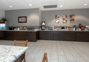 A modern kitchen with a marble countertop, a coffee machine, and a refrigerator. - Red Roof Inn Gulfport - Biloxi Airport (Gulfport)