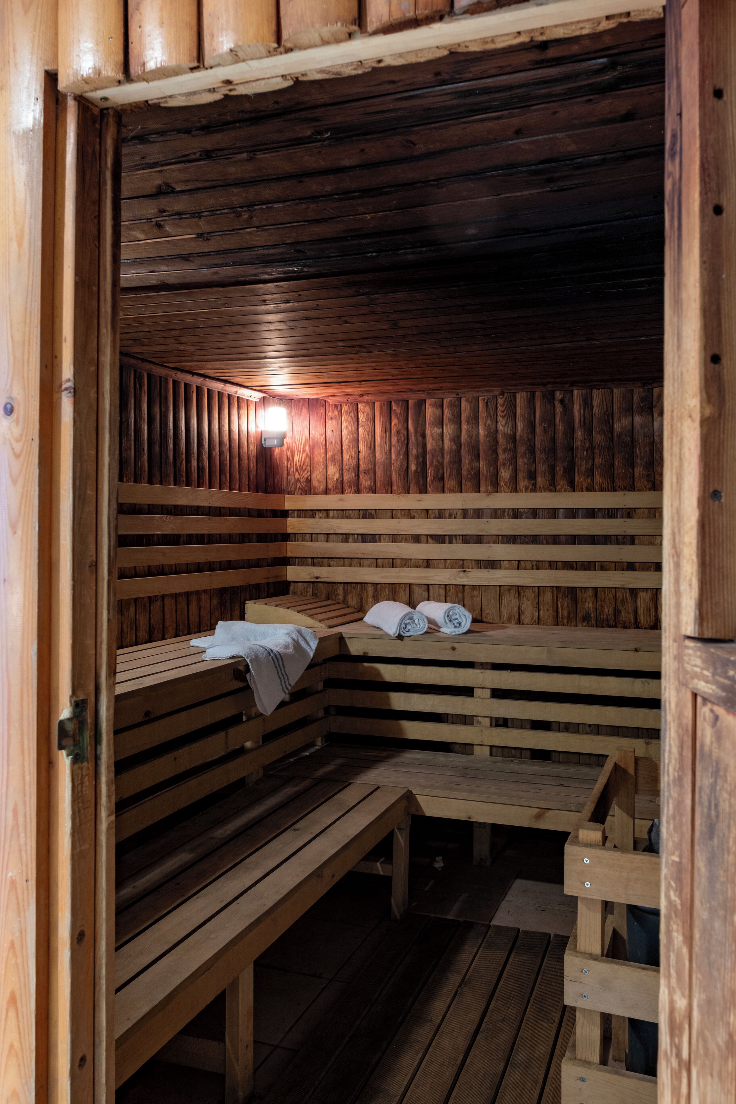 A wooden sauna with benches and a bench seat.