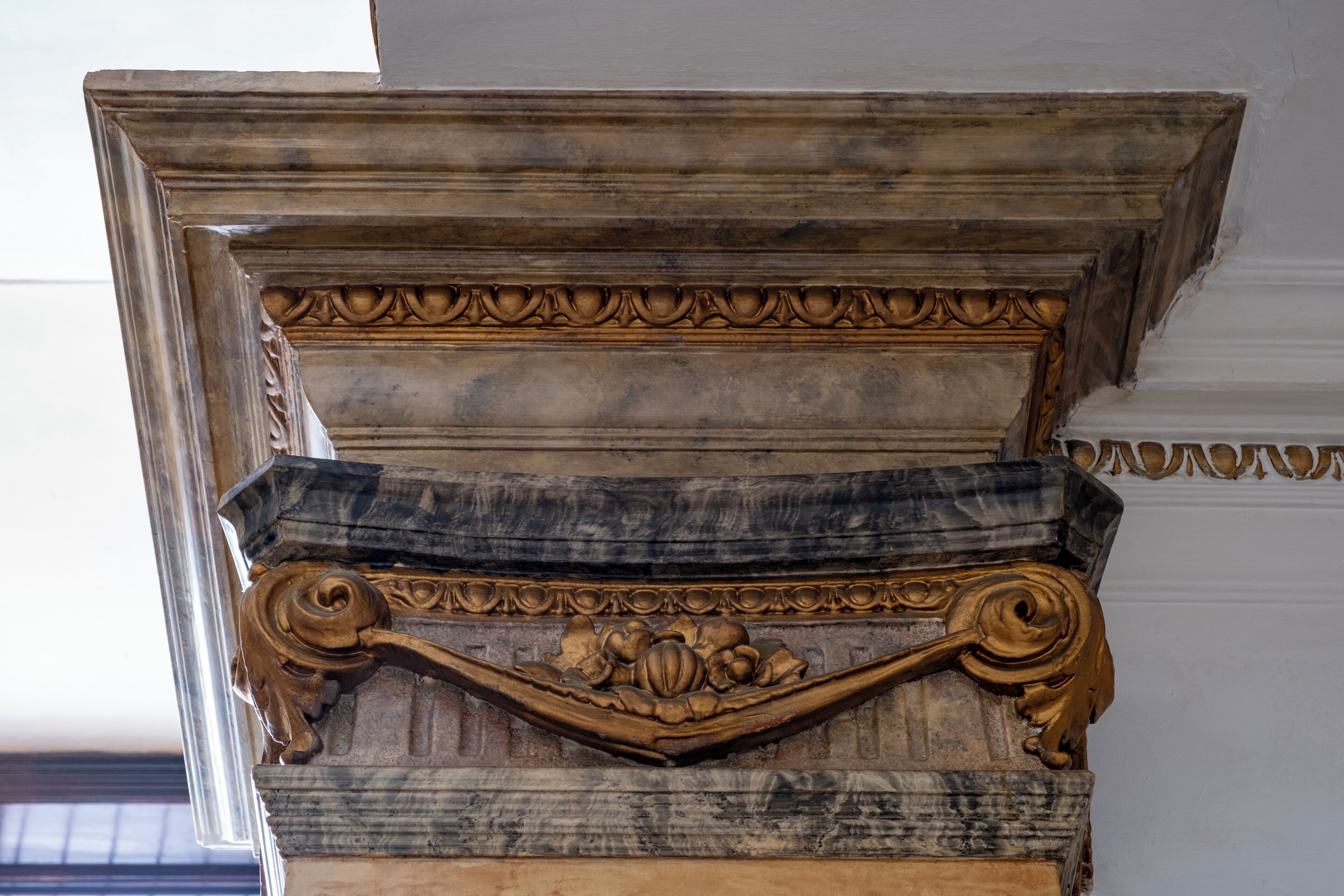 Un élément architectural élaboré, orné de motifs floraux sculptés et présentant un motif en pierre à plusieurs niveaux.