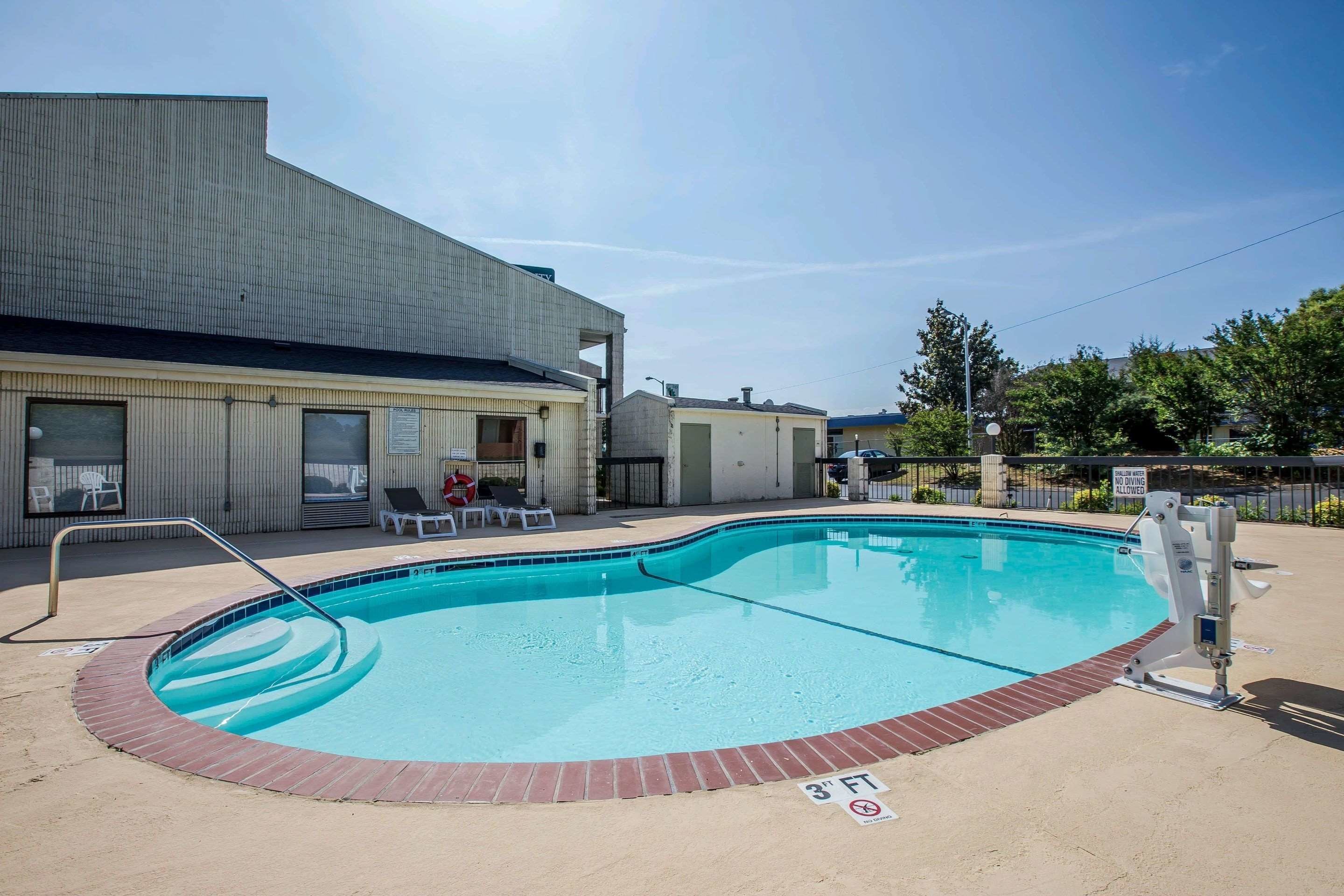 A swimming pool with a brick edge, a metal ladder, and a sign indicating a 3' height limit.
