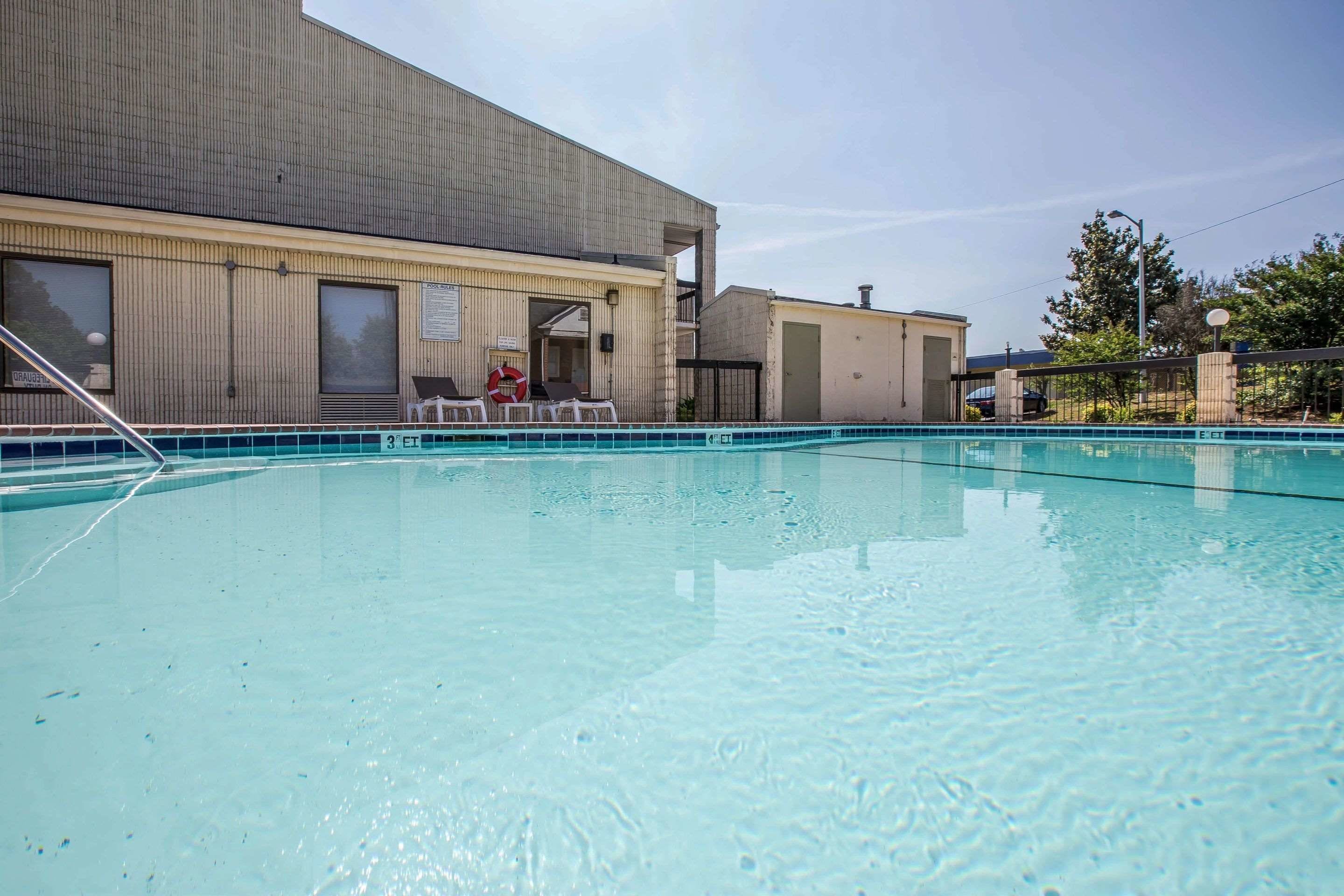 A swimming pool area with a building in the background.