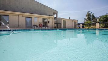 A swimming pool area with a building in the background.