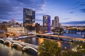 A cityscape with modern buildings, a river, and a bridge. - Courtyard by Marriott Downtown Grand Rapids (Grand Rapids)