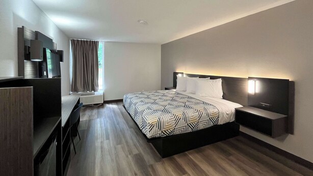 A modern hotel room with a large bed, a desk, and a TV. - Motel 6 Nacogdoches, TX-SFA University (Nacogdoches)