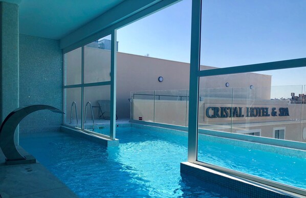 Una piscina cubierta, una piscina al aire libre de temporada, sombrillas