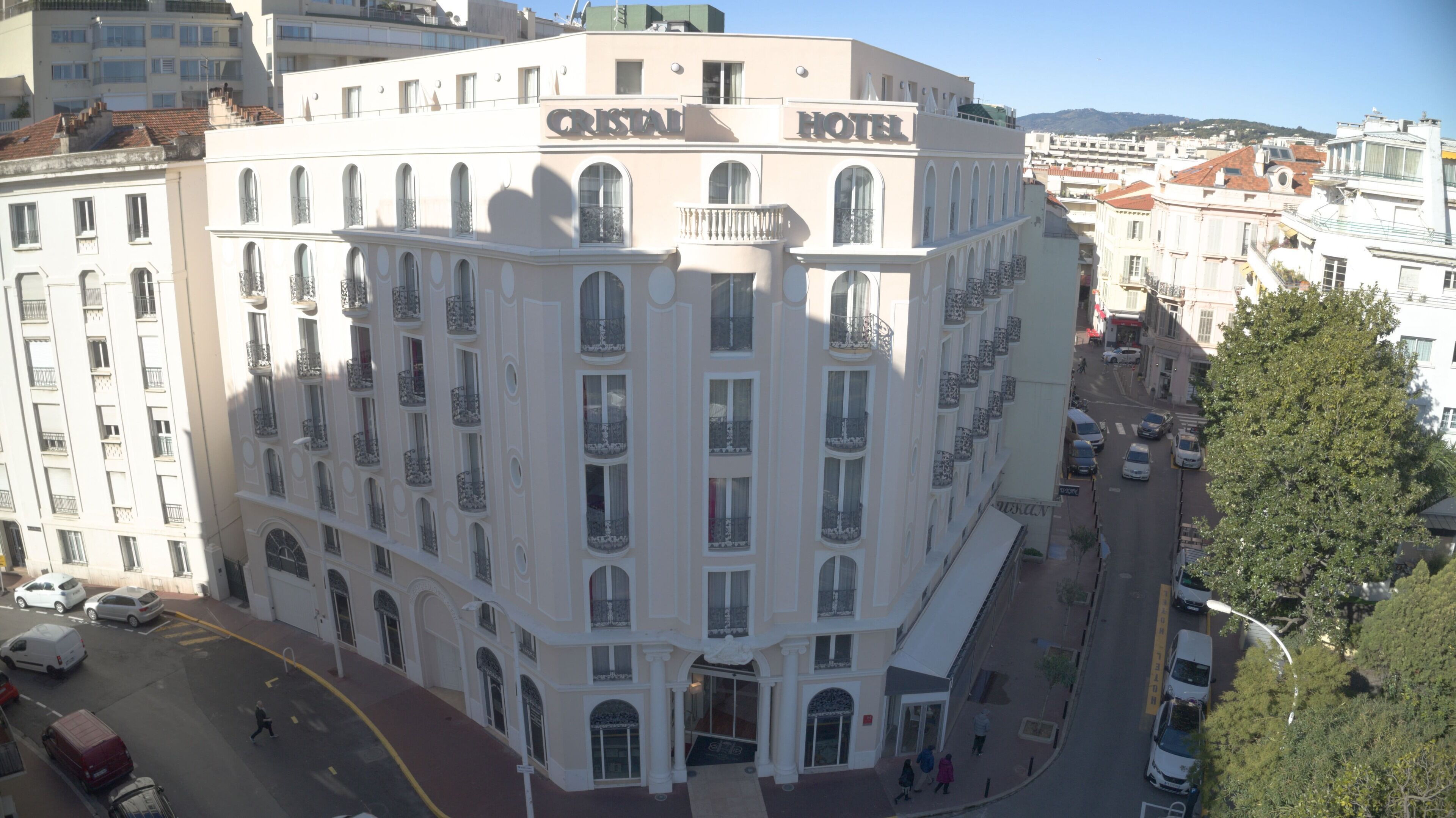 A multi-story hotel with a classic architectural style, featuring arched windows and balconies.