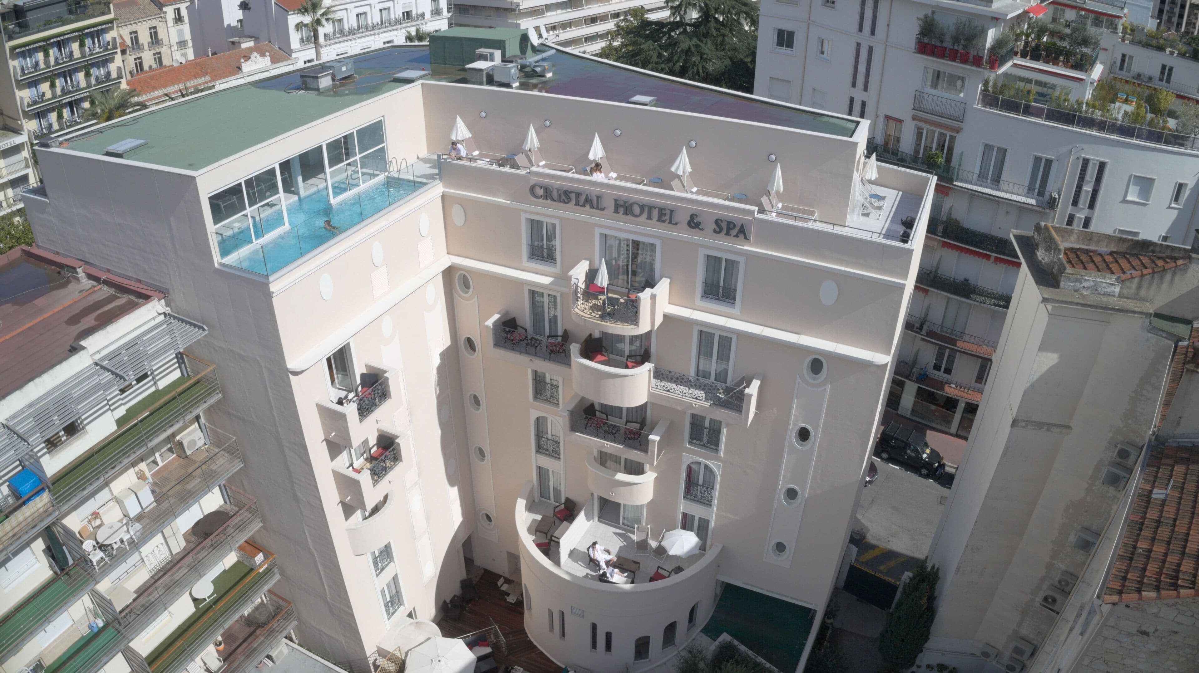 Un hôtel à plusieurs étages doté d’une piscine sur le toit et d’espaces de détente en plein air.