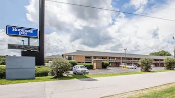 A Rodeway Inn with a brick building, a parking lot, and a clear sky.