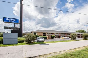 A Rodeway Inn with a brick building, a parking lot, and a clear sky. - Rodeway Inn Expo Center (Spartanburg)