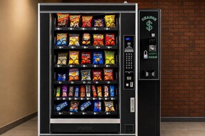 A vending machine with a variety of snack options, including chips and candies, and a digital payment interface. - Rodeway Inn Expo Center (Spartanburg)