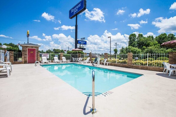 Un espace piscine avec des chaises longues et un poste de surveillance pour les sauveteurs dans un hôtel.