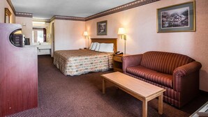 Una habitación de hotel con cama, sofá, mesa y escritorio con teléfono.