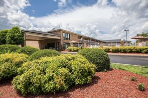A multi-story building with a covered entrance and a parking area. - Rodeway Inn Expo Center (Spartanburg)