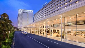 A hotel with a modern glass facade, a prominent 'Pullman' sign, and a well-lit entrance area. - Pullman Jakarta Indonesia (Jakarta)