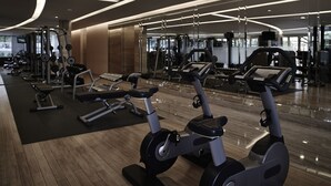 A modern gym with various exercise equipment, including treadmills and weight machines, and a polished wooden floor. - Pullman Jakarta Indonesia (Jakarta)