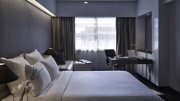 Una habitación de hotel moderna con una cama grande, un escritorio y una silla.