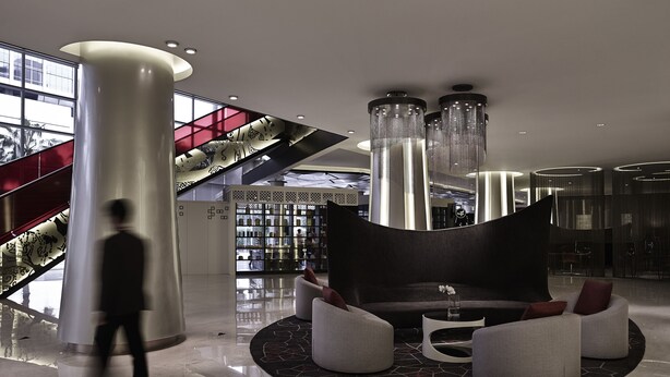 A modern lobby with a central seating area, a staircase, and a glass wall. - Pullman Jakarta Indonesia (Jakarta)