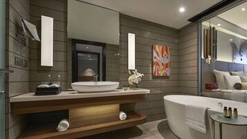 A modern bathroom with a large sink, a bathtub, and a vanity with a mirror.