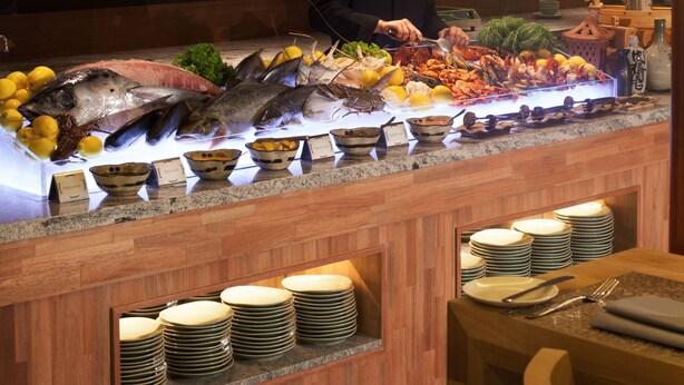 A buffet setup with seafood, bowls, and plates.