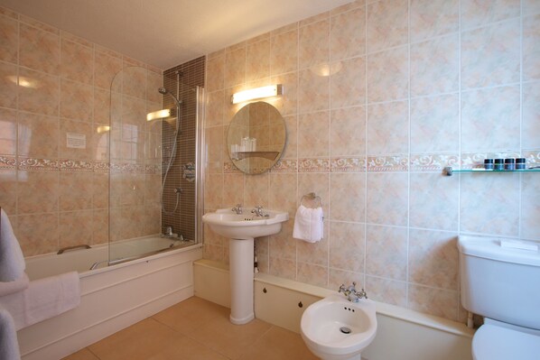 A bathroom with a bathtub, sink, and toilet.