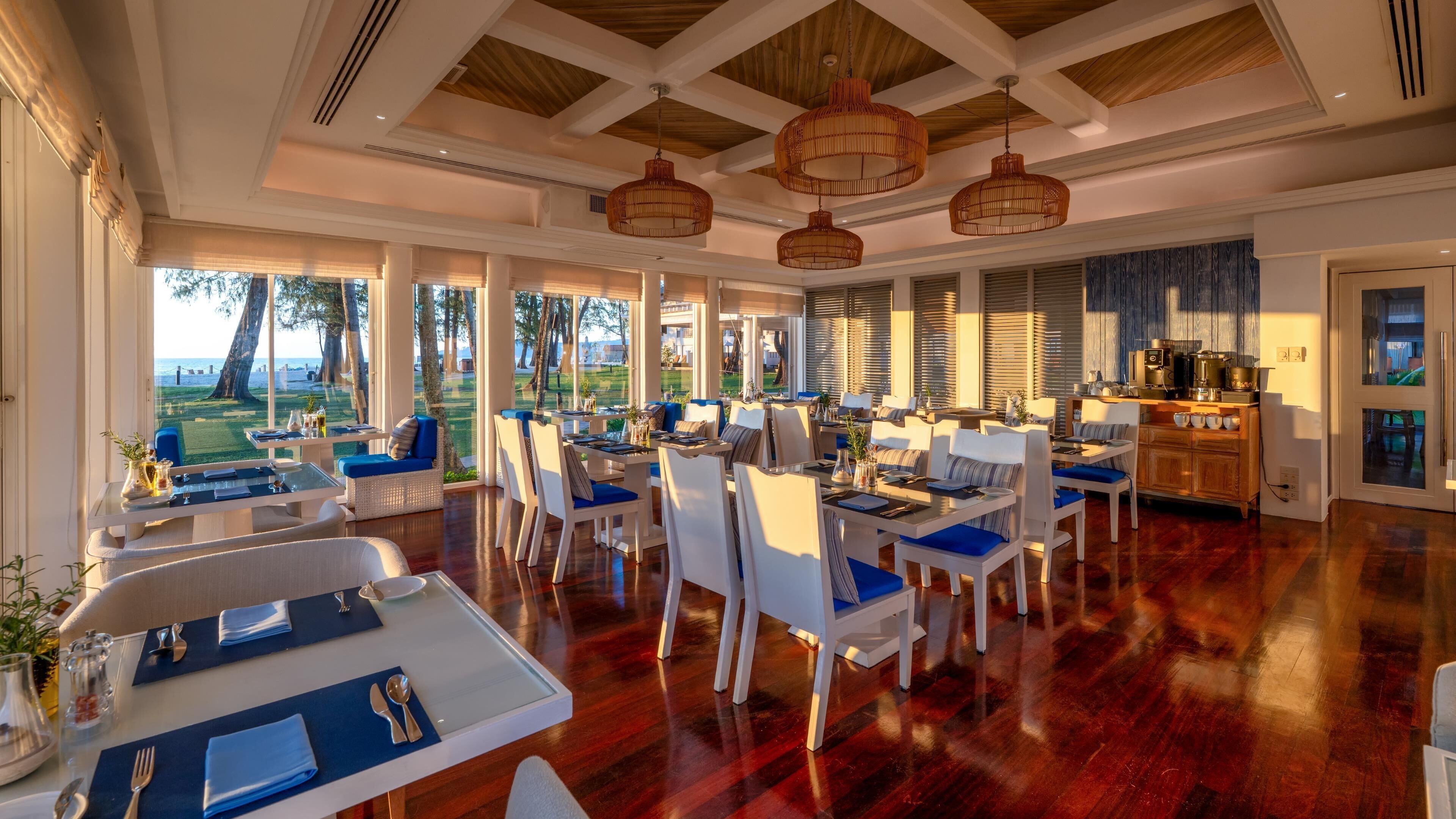 Un comedor amplio con techos altos, ventanas grandes y vistas al exterior.