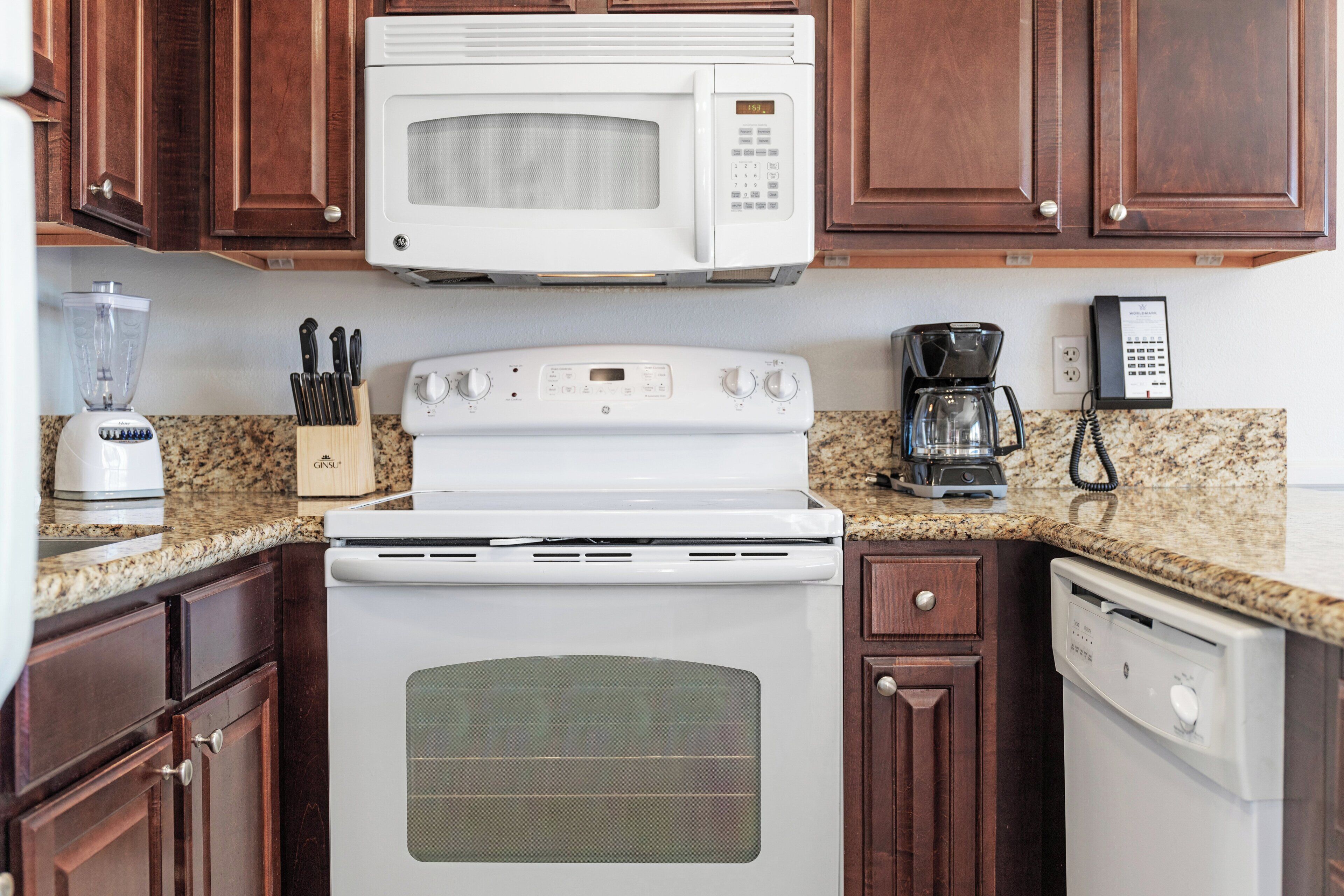 A kitchen with a microwave, stove, coffee maker, and dishwasher.