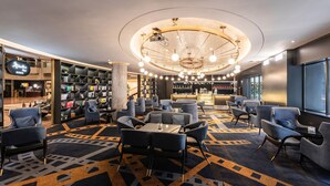 A modern hotel lobby with a central bar, seating areas, and a large bookshelf. - Crowne Plaza Hotel Shanghai by IHG (Shanghai)