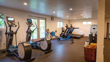 Un gimnasio con bicicletas estáticas, cintas de correr y equipamiento de ejercicio.