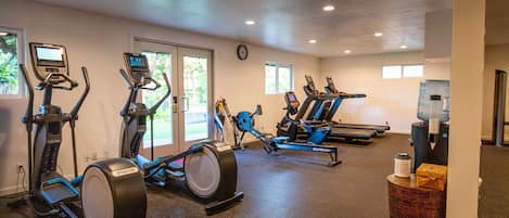 Un gimnasio con bicicletas estáticas, cintas de correr y equipamiento de ejercicio.