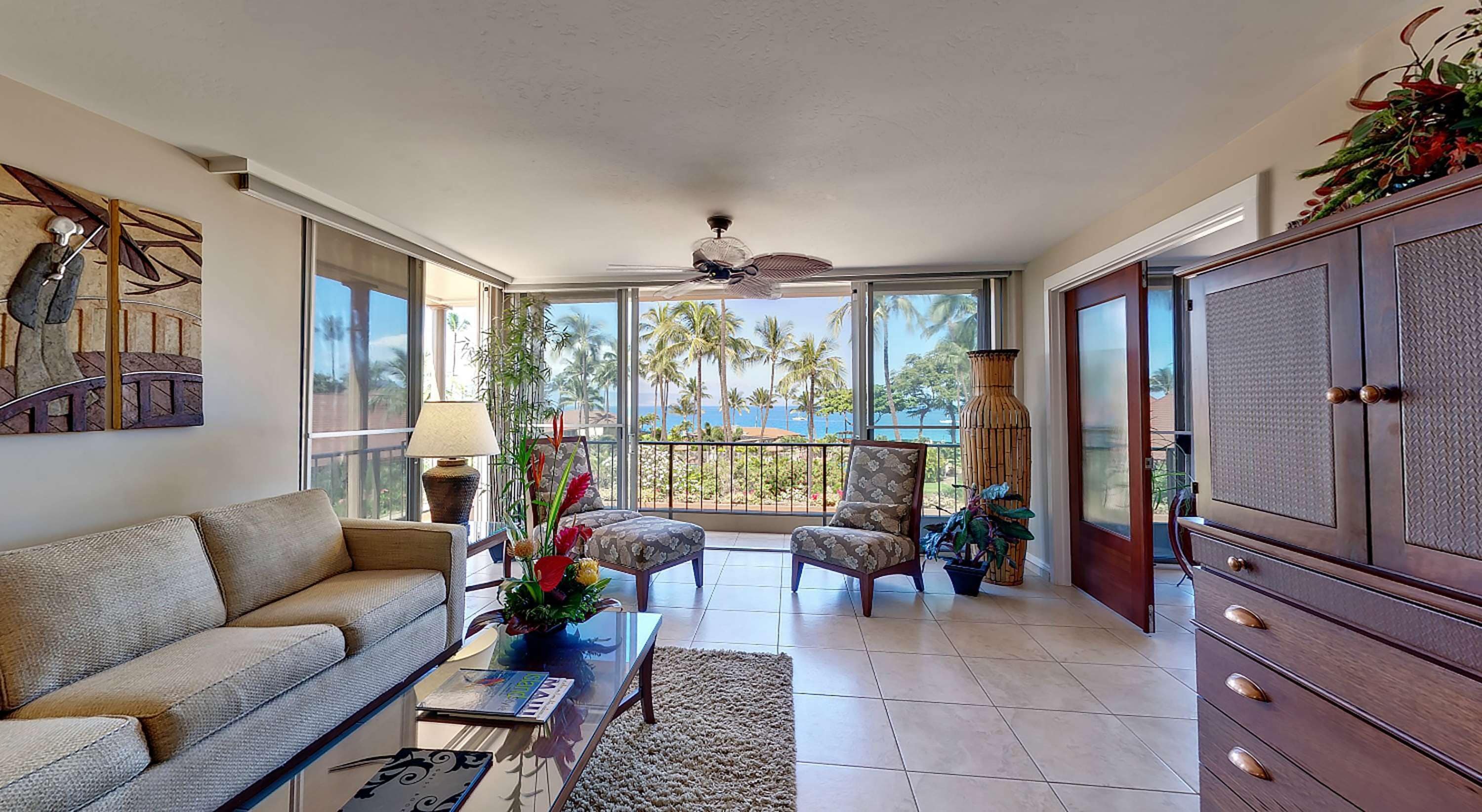 A spacious living room with a sofa, armchairs, a coffee table, and a large cabinet.