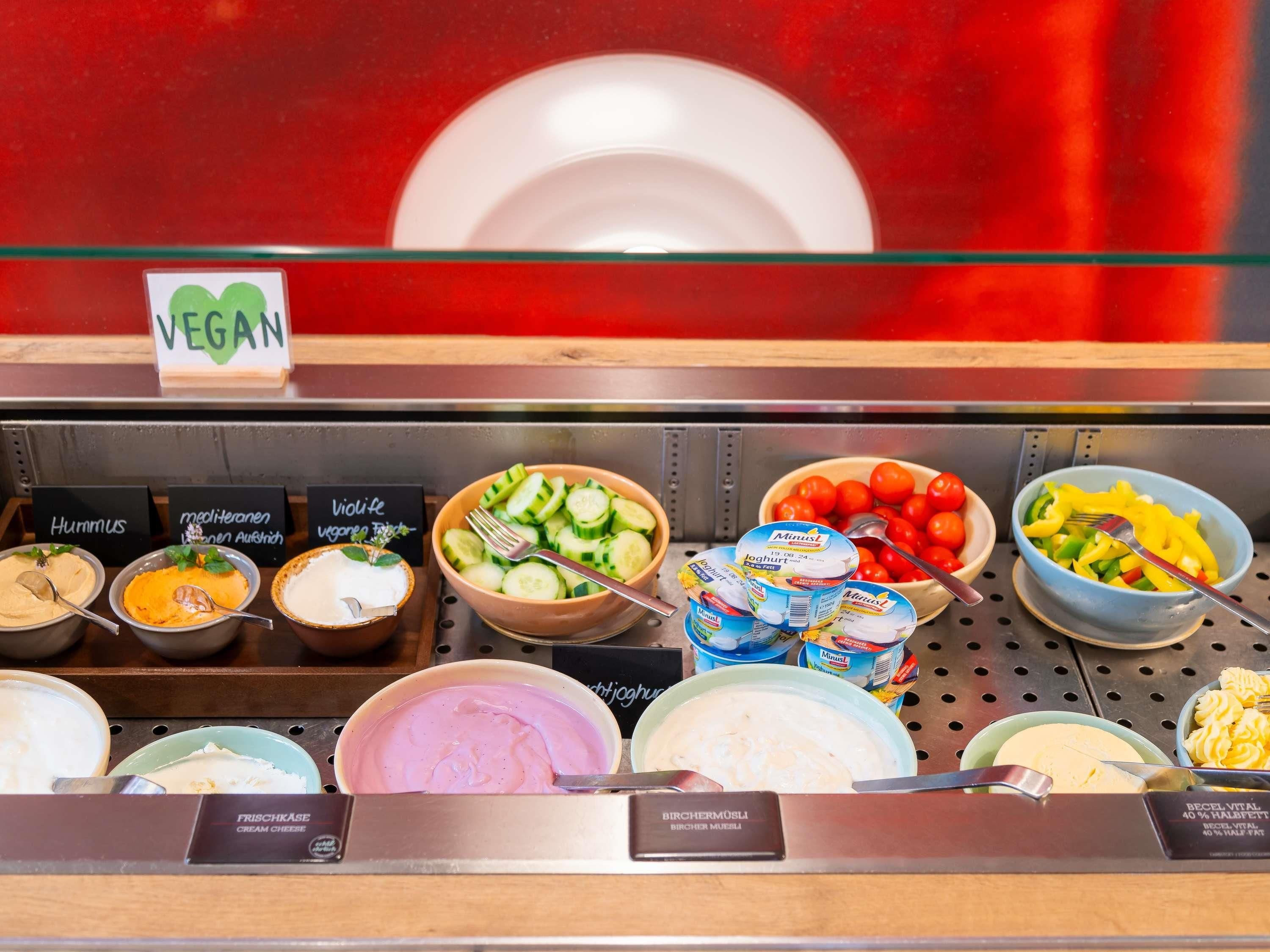 Variedad de opciones veganas, como hummus, yogur y verduras frescas.