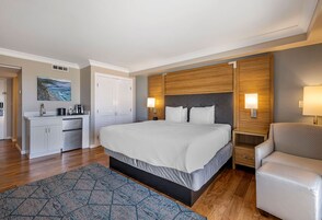 A modern hotel room with a large bed, bedside tables, a desk, and a chair.
