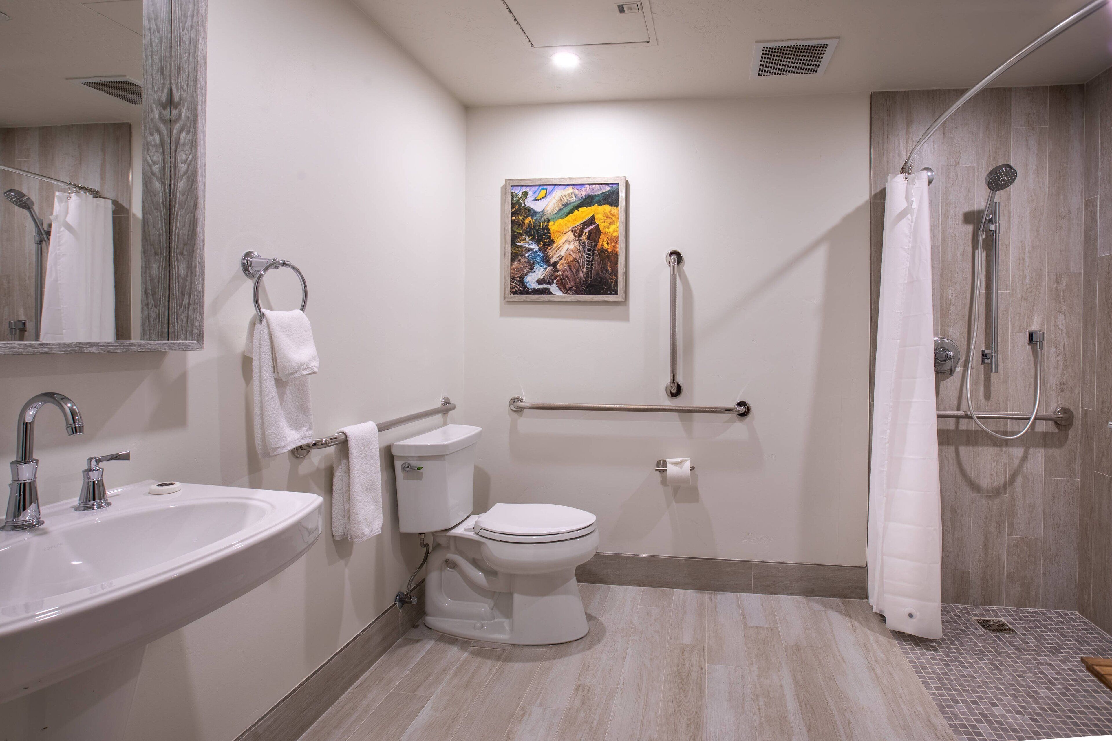 Een moderne badkamer met een wastafel, toilet en douche.